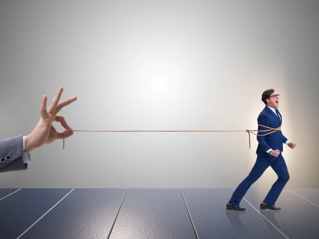 A businessman being held back by a rope, illustrating how businesses can use employee health insurance and benefits to improve retention and prevent talent loss.